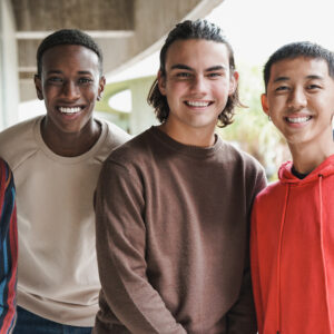 Group of happy multiethnic boys smiling on camera at school outdoor
